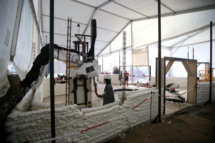 Employees work to build a 3D printed social housing building called "Yhnova", using a construction 3D printing technique known as BatiPrint3D and developed by researchers from the University of Nantes, in Nantes, France, September 19, 2017. REUTERS/Stephane Mahe