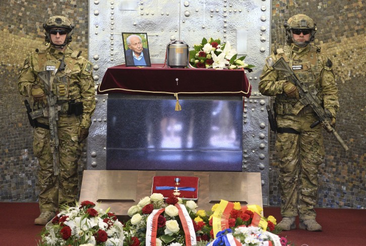 Polish Army soldiers in combat gear stand next to the urn with ashes of WWII hero Stanislaw Likiernik during the funeral ceremony at the Powazki cemetery, in Warsaw, Poland, Monday, May 21, 2018. (AP Photo/Alik Keplicz)