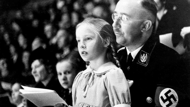FILE - Chief of the German Police and Minister of the Interior Heinrich Himmler, with his daughter Gudrun on his lap, watch an indoor sports display in Berlin, Germany on March 6, 1938. (AP Photo)