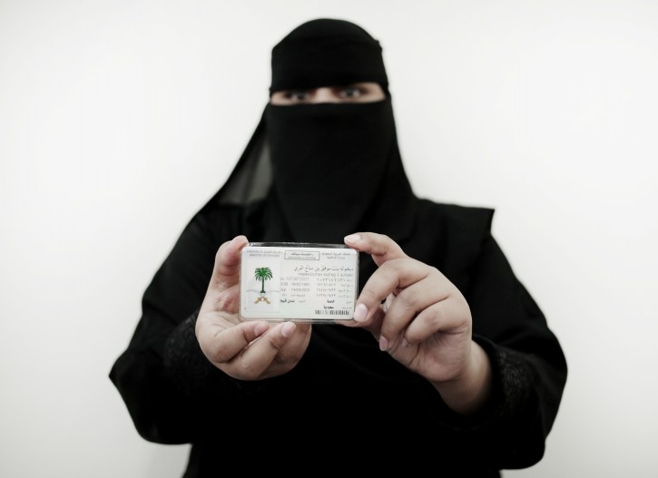 In this June 23, 2018 photo, 27-year old Mabkhoutah al-Mari poses for a photograph holding her new car license at the Saudi Driving School inside Princess Nora University in Saudi Arabia. (AP Photo/Nariman El-Mofty)