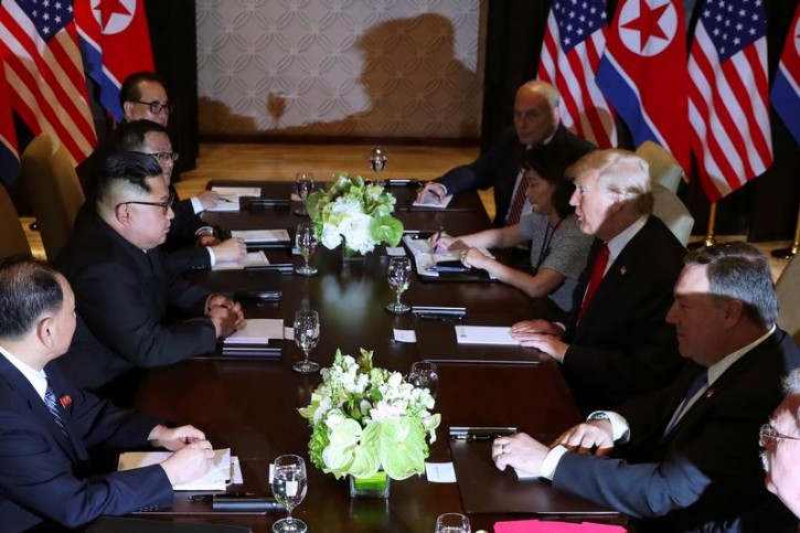 U.S. President Donald Trump speaks with North Korea's leader Kim Jong Un before their expanded bilateral meeting at the Capella Hotel on Sentosa island in Singapore June 12, 2018. REUTERS/Jonathan Ernst