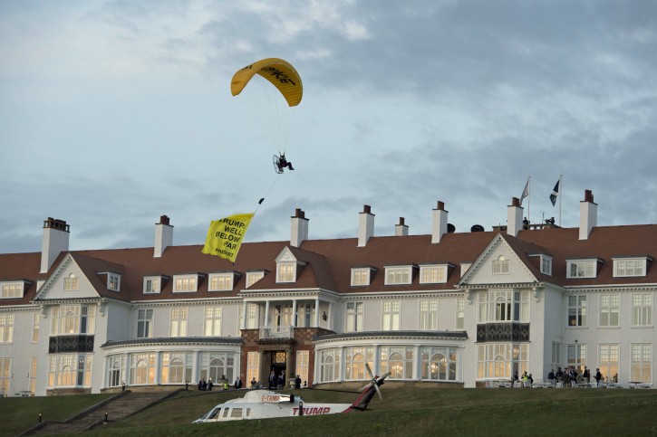 A Greenpeace protester flying a microlight passes over Donald Trump's resort in Turnberry, South Ayrshire, with a banner reading "Trump: Well Below Par", shortly after the US President arrived at the hotel. PRESS ASSOCIATION Photo. 