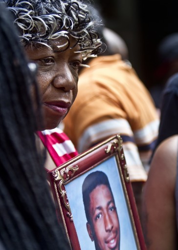 FILE - In this July 7, 2015 file photo Gwen Carr holds a picture of her son, Eric Garner, during a news conference outside New York Gov. Andrew Coumo's New York office. The New York Police Department says it's moving ahead with disciplinary proceedings against a police officer accused in the chokehold death of Garner, an unarmed man. A letter dated Monday, July 16, 2018, from an NYPD lawyer informed the Department of Justice that it would no longer wait for federal authorities to decide whether to charge Officer Daniel Pantaleo in the Garner case. (AP Photo/Bebeto Matthews, File)