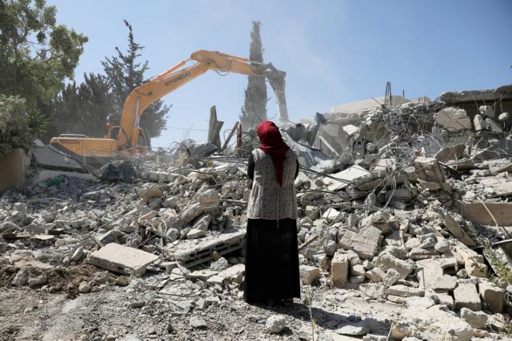 Fawzia stands on the ruins of her house, after her Palestinian ex-husband demolished the dwelling to not face the prospect of Israeli settlers moving in after he lost a land ownership case in Israeli courts, in the East Jerusalem neighbourhood of Beit Hanina, July 19, 2018.  REUTERS/Ammar Awad