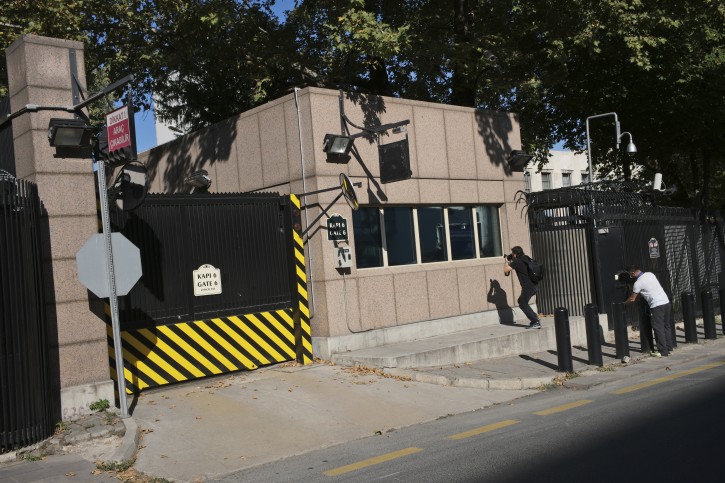 Members of the media take pictures of the damage to a security booth by a shot fired, outside the U.S. Embassy in Ankara, Turkey, Monday, Aug. 20, 2018. Shots were fired at a security booth outside the embassy in Turkey's capital early Monday, but U.S. officials said no one was hurt. Ties between Ankara and Washington have been strained over the case of an imprisoned American pastor, leading the U.S. to impose sanctions, and increased tariffs that sent the Turkish lira tumbling last week. (AP Photo/Burhan Ozbilici)