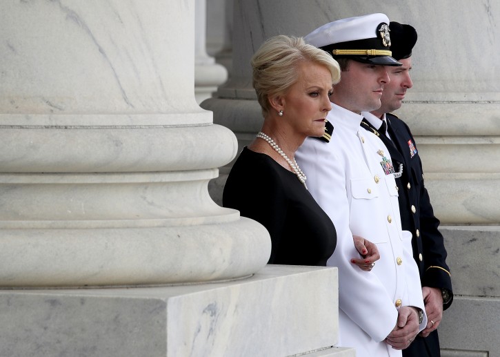John McCain's widow Cindy McCain (L), and his sons Jack (C) and James (R) watch joint service members of a military casket team carry the casket of Senator John McCain into the US Capitol, where he will lie in state for the rest of the day in Washington, DC, USA, 31 August 2018.