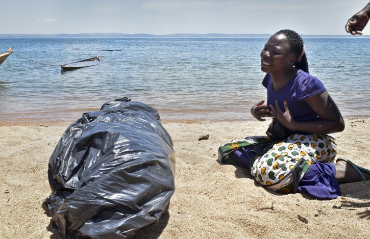 A woman cries beside the body of her sister, a victim of the MV Nyerere passenger ferry, as she awaits transportation for burial on Ukara Island, Tanzania Saturday, Sept. 22, 2018. AP