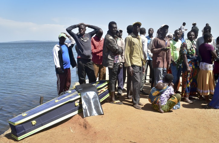 Residents and relatives of victims of the MV Nyerere passenger ferry stand by an empty coffin waiting to be used to transport the bodies of victims, on Ukara Island, Tanzania Saturday, Sept. 22, 2018. AP