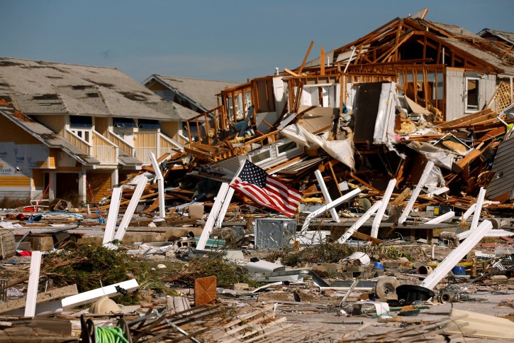 An American flag flies amongst rubble left in the aftermath of Hurricane Michael in Mexico Beach, Florida, U.S. October 11, 2018. REUTERS/Jonathan Bachman