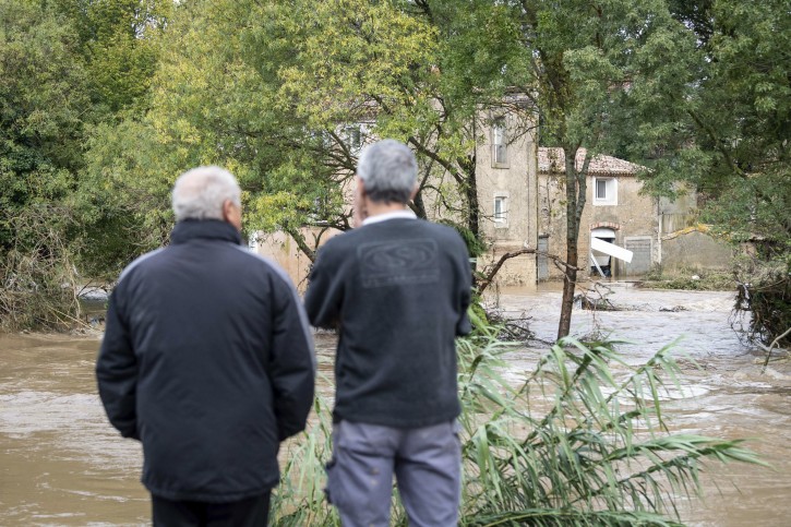 Residents watch the waters after flash floods in the town of Villegailhenc, southern France, Monday, Oct.15, 2018. Flash floods tore through towns in southwest France, turning streams into raging torrents that authorities said killed several people and seriously injured at least five others. (AP Photo/Fred Lancelot)