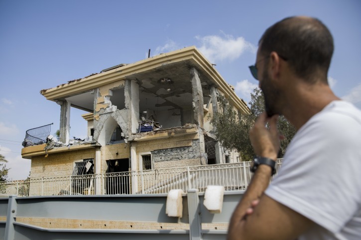 A man watches a house that was hit by a missile fired from Gaza Strip, in the city of Beersheba, southern Israel, Wednesday, Oct. 17, 2018.  (AP Photo/Tsafrir Abayov)