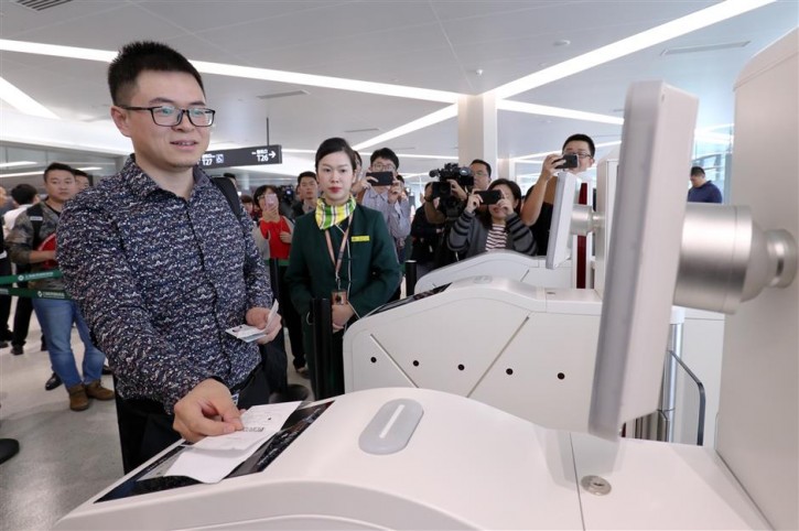 Zhang Yinghui, a Spring Airlines passenger who took a flight from Hongqiao to Shenzhen on Monday, scans his boarding pass on a self-service boarding machine equipped with facial recognition capabilities at the T1 terminal of Hongqiao International Airport.