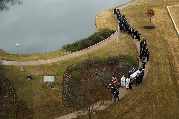 The flag-draped casket of former President George H.W. Bush is carried by a joint services military honor guard followed by family members for burial at the George H.W. Bush Presidential Library and Museum Thursday, Dec. 6, 2018, in College Station, Texas. (AP Photo/Jeff Roberson, Pool)