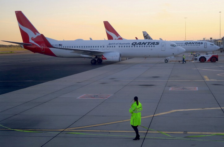 FILE PHOTO: Workers can be seen near Qantas Airways' Boeing 737-800 aircraft on the tarmac at Adelaide Airport, Australia, Aug. 22, 2018. REUTERS/David Gray/File Photo