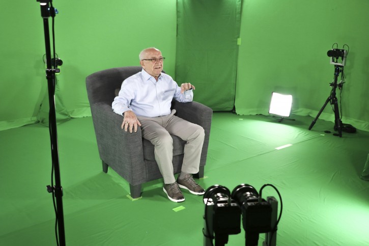 This August 2018 photo shows Holocaust survivor Max Glauben sitting in an interactive green screen room while filming a piece for the Dallas Holocaust Museum in Dallas. Glauben will be the latest to have his story recorded in such a way that generations to come will be able to ask his image questions. Glauben, who turns 91 on Monday, had lost his mother, father and brother at the hands of the Nazis when U.S. troops rescued him while he was on a death march. (McGuire Boles/Dallas Holocaust Museum via AP)
