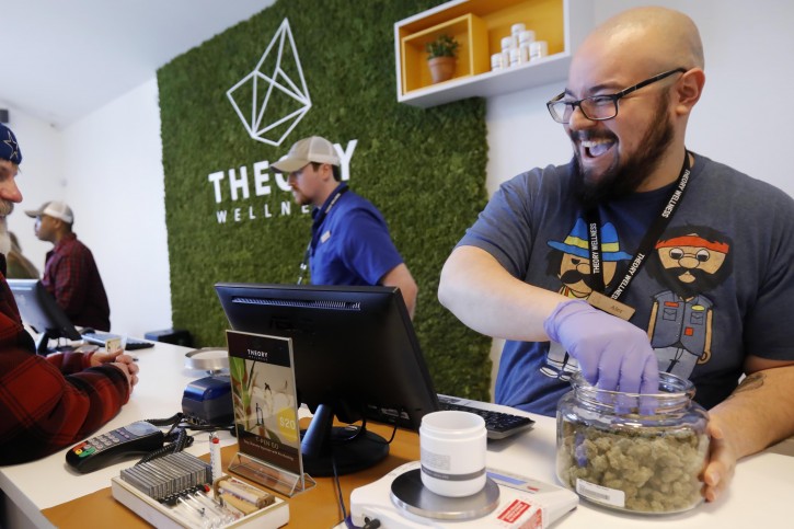 FILE- In this  Jan. 11, 2019 file photo, Alex Premoli makes the first sale to a customer on the opening day of recreational marijuana sales at Theory Wellness in Great Barrington, Mass. New York ligislators will be able to look toward their neighboring state, who became the latest state to legalize the recreational use of marijuana, for tips on how regulate and tax its use. (Stephanie Zollshan/The Berkshire Eagle via AP, File)