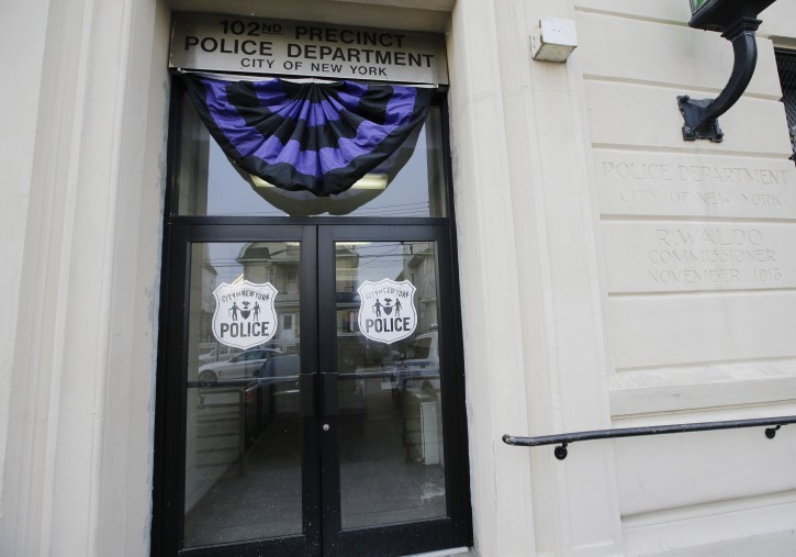 The entrance to the 102nd precinct is shown Wednesday, Feb. 13, 2019, in New York. A New York City police detective was shot and killed by friendly fire Tuesday night as officers confronted a robbery suspect who turned out to be armed with a replica handgun, Commissioner James O'Neill said. (AP Photo/Frank Franklin II)