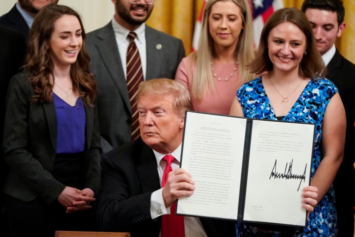 U.S. President Donald Trump shows an executive order linking "free speech" efforts at public universities to federal grants during a signing ceremony in the East Room at the White House in Washington, U.S., March 21, 2019. REUTERS/Joshua Roberts