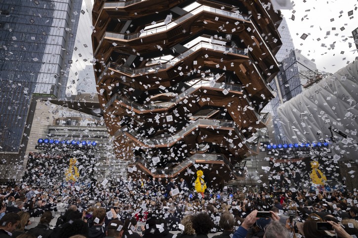 Confetti swirls around "Vessel" on its opening day at Hudson Yards, Friday, March 15, 2019, in New York.  (AP Photo/Mark Lennihan)