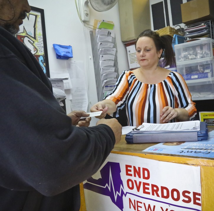 In this Friday, March 15, 2019 photo, Laura Levine prepares to register a new client at Vocal NY, an organization that works with addicts, where she is the health educator and coordinator for the opioid reversal drug Narcan, in the Brooklyn borough of New York. New York state is considering providing medication-assisted treatment to all prison and jail inmates struggling with opioid addiction. (AP Photo/Bebeto Matthews)
