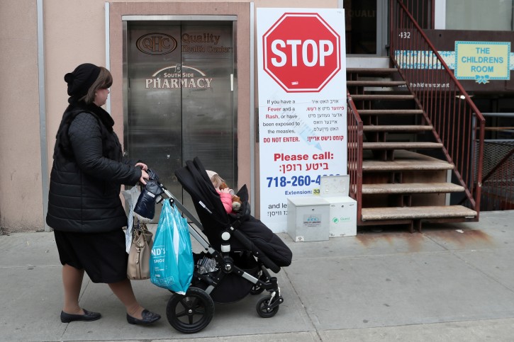 A sign warning people of measles in the ultra-Orthodox Jewish community of Williamsburg, two days after New York City Mayor Bill de Blasio declared a public health emergency in parts of Brooklyn in response to a measles outbreak, is seen in New York, U.S., April 11, 2019. REUTERS/Shannon Stapleton/File Photo