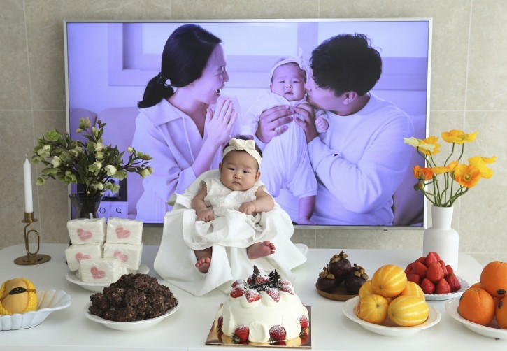 In this April 9, 2019, photo, Lee Dong Kil's daughter Lee Yoon Seol sits to celebrate her the 100th day of the birth at Lee's house in Daejeon, South Korea. Just two hours after Lee's daughter was born on New Year's Eve, the clock struck midnight, 2019 was ushered in, and the infant became 2-years-old.(AP Photo/Ahn Young-joon)