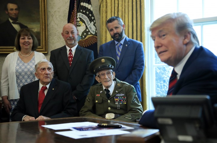 President Donald Trump listens to World War II veterans, seated from left, Paul Kriner and Floyd Wigfield, in the Oval Office of the White House in Washington, Thursday, April 11, 2019.   (AP Photo/Manuel Balce Ceneta)