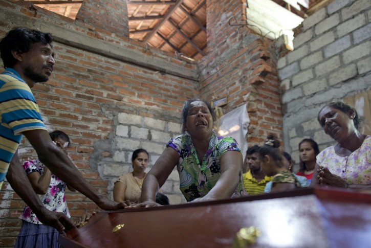 Lalitha, center weeps standing at the coffin with the remains of 12-year old niece, Sneha Savindi, who was a victim of Easter Sunday bomb blast at St. Sebastian Church in Negambo, Sri Lanka, Monday, April 22, 2019.  AP