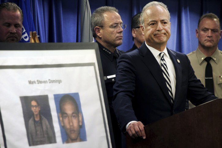 United States Attorney Nick Hanna stands next to photos of Mark Steven Domingo, during a news conference in Los Angeles on Monday, April 29, 2019. AP