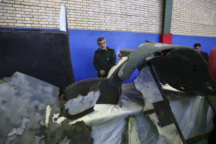 Head of the Revolutionary Guard's aerospace division Gen. Amir Ali Hajizadeh looks at debris from what the division describes as the U.S. drone which was shot down on Thursday, in Tehran, Iran, Friday, June 21, 2019. (Meghdad Madadi/Tasnim News Agency/via AP)