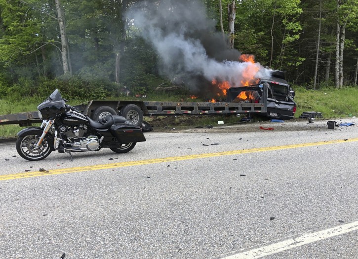 This photo provided by Miranda Thompson shows the scene where several motorcycles and a pickup truck collided on a rural, two-lane highway Friday, June 21, 2019 in Randolph, N.H. New Hampshire State Police said a 2016 Dodge 2500 pickup truck collided with the riders on U.S. 2 Friday evening. The cause of the deadly collision is not yet known. The pickup truck was on fire when emergency crews arrived. (Miranda Thompson via AP)
