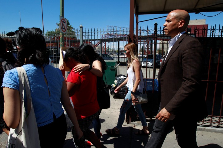 FILE PHOTO: U.S. Senator Cory Booker (D-NJ) escorts migrants seeking asylum towards El Paso, Texas, U.S., as seen at Paso del Norte border crossing bridge in Ciudad Juarez, Mexico July 3, 2019. REUTERS/Jose Luis Gonzalez