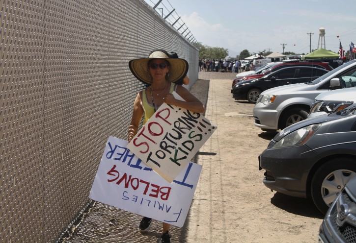 A grandmother protesting the treatment of children in Border Patrol custody walks back to her car by a fence at a holding center in Clint, Texas, July 1, 2019. AP