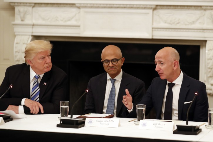 FILE - In this June 19, 2017, file photo President Donald Trump, left, and Satya Nadella, Chief Executive Officer of Microsoft, center, listen as Jeff Bezos, Chief Executive Officer of Amazon, speaks during an American Technology Council roundtable in the State Dinning Room of the White House in Washington.  (AP Photo/Alex Brandon, File)