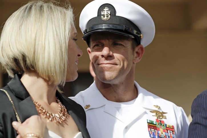 FILE - In this July 2, 2019 file photo, Navy Special Operations Chief Edward Gallagher, right, walks with his wife, Andrea Gallagher as they leave a military court on Naval Base San Diego, Tuesday, July 2, 2019, in San Diego. The Navy has dismissed charges against an officer for allegedly not reporting war crimes by Gallagher, who was later acquitted of murder. A Navy official with knowledge of the decision not authorized to speak publicly confirmed said charges against Lt. Jacob Portier were dropped Thursday, Aug. 1, 2019. (AP Photo/Gregory Bull, File)